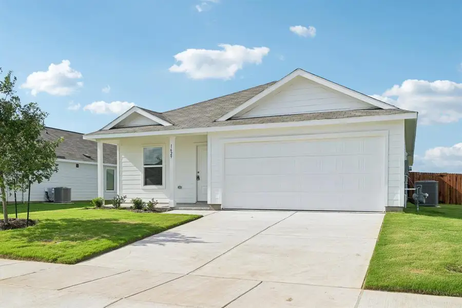 Single story home featuring roof with shingles, an attached garage, and concrete driveway