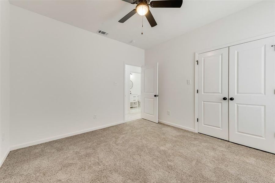 Unfurnished bedroom with a closet, ceiling fan, and light colored carpet