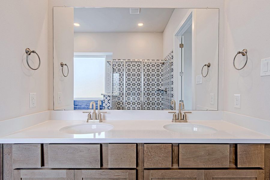 A spacious dual-sink vanity provides ample room for morning routines, featuring sleek brushed nickel fixtures and a crisp, clean aesthetic. A spacious dual-sink vanity provides ample room for morning routines, featuring sleek brushed nickel fixtures and a crisp, clean aesthetic.