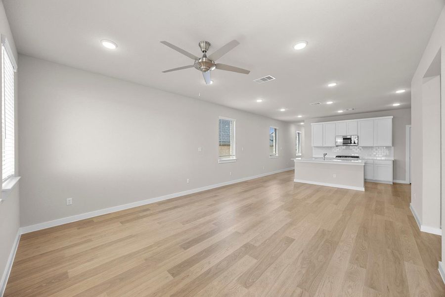 An open-concept living area boasts a modern kitchen with a large island and ample space for entertaining. An open-concept living area boasts a modern kitchen with a large island and ample space for entertaining.