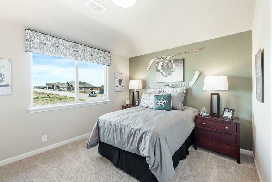 Kids bedroom with hockey-themed decor, green accent wall, and carpet flooring Kids bedroom with hockey-themed decor, green accent wall, and carpet flooring