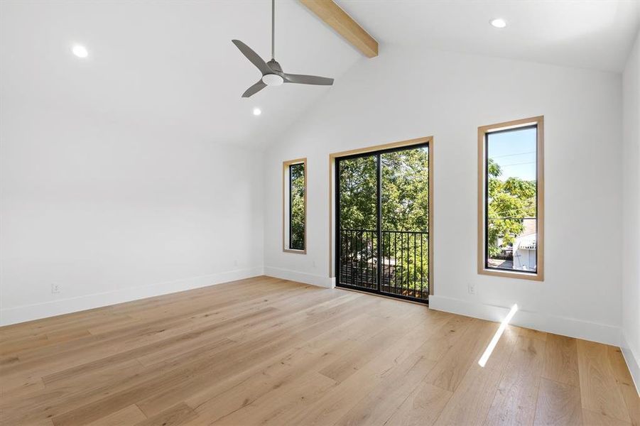 Empty room with light hardwood / wood-style floors, beam ceiling, ceiling fan, and a wealth of natural light