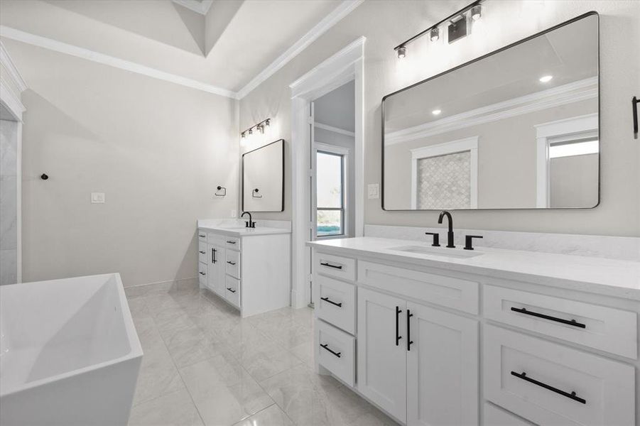 Bathroom featuring vanity, a bathtub, and crown molding