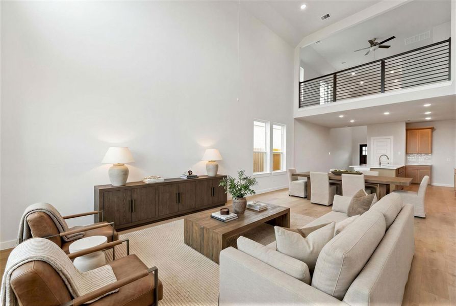 The open-concept downstairs layout seamlessly connects the kitchen, dining and living areas, creating the perfect space for gathering and entertaining. Virtually staged representation of the family room.