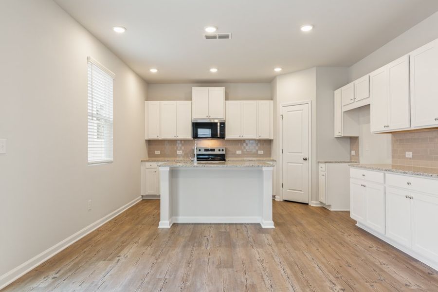 A kitchen with white cabinets.