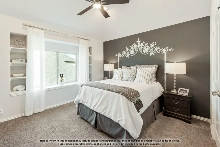 Bedroom with dark gray accent wall, ceiling fan, built-in shelves, and carpet flooring