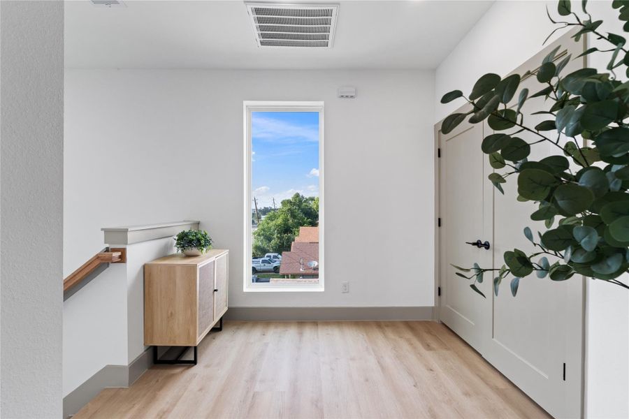 This bright and versatile landing makes a perfect transition space—ideal for a reading nook, gallery wall, or drop zone. Natural light floods in through a tall picture window, highlighting the warm-toned SPC flooring and clean architectural lines throughout. This bright and versatile landing makes a perfect transition space—ideal for a reading nook, gallery wall, or drop zone. Natural light floods in through a tall picture window, highlighting the warm-toned SPC flooring and clean architectural lines throughout.