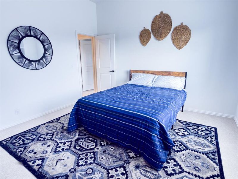 Bedroom featuring light carpet and baseboards