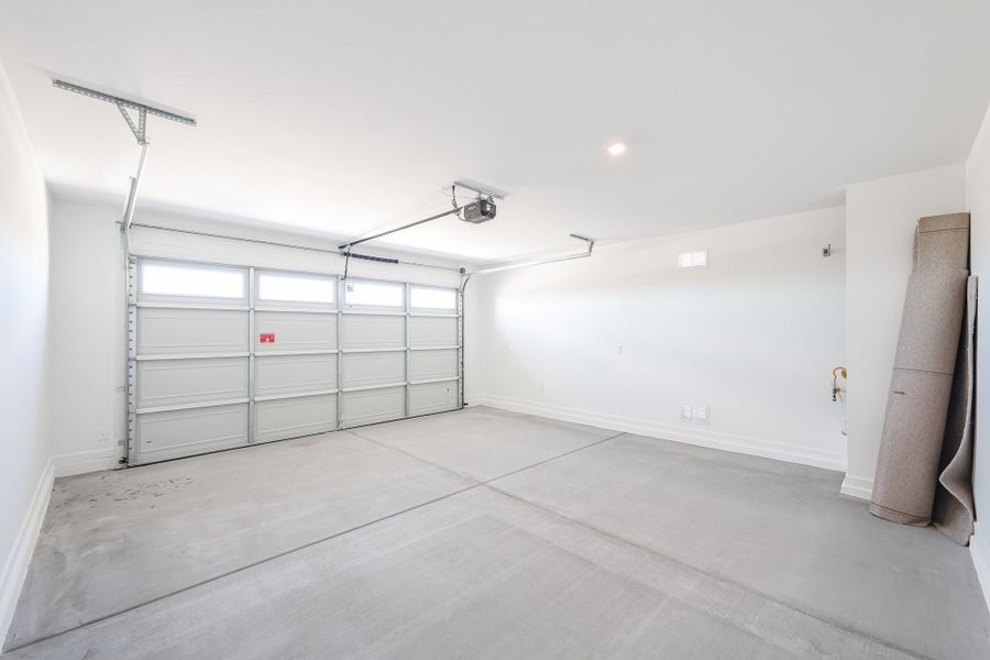 A room with a large white door and a light on the ceiling.