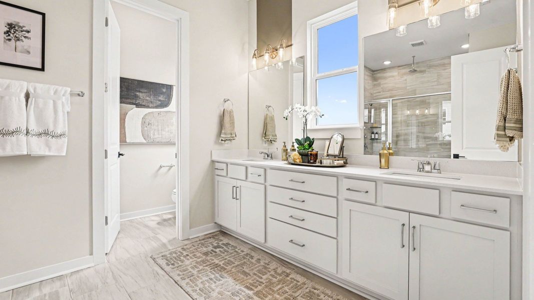 Primary bathroom with dual vanity and bright natural lighting