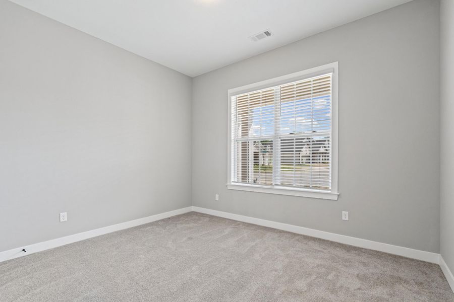 Empty room featuring baseboards and light colored carpet