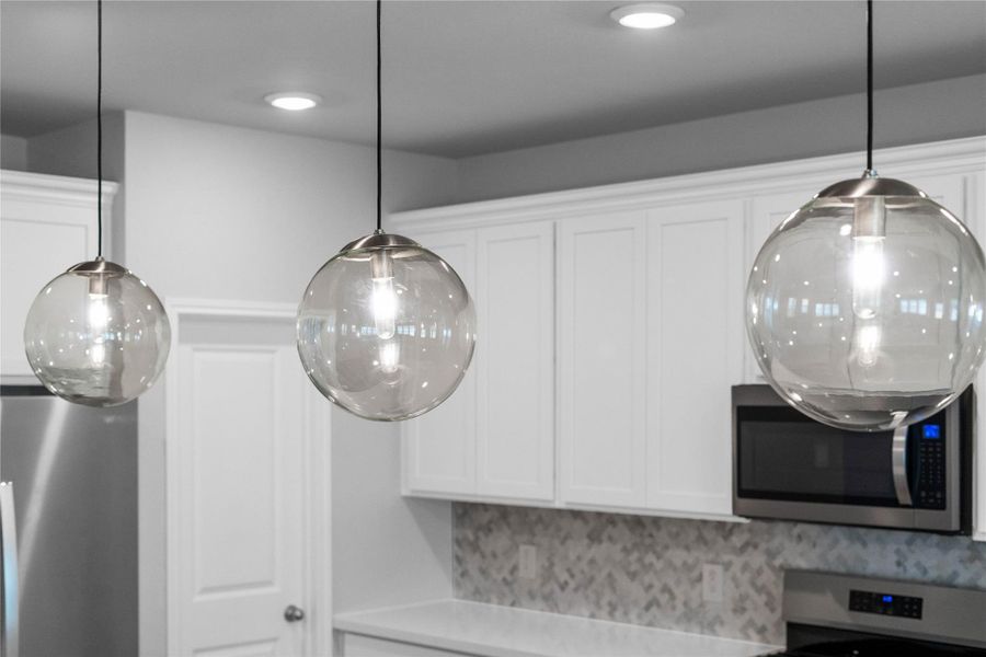Atwell Pendant Brushed Nickel lights that hang over the kitchen island.