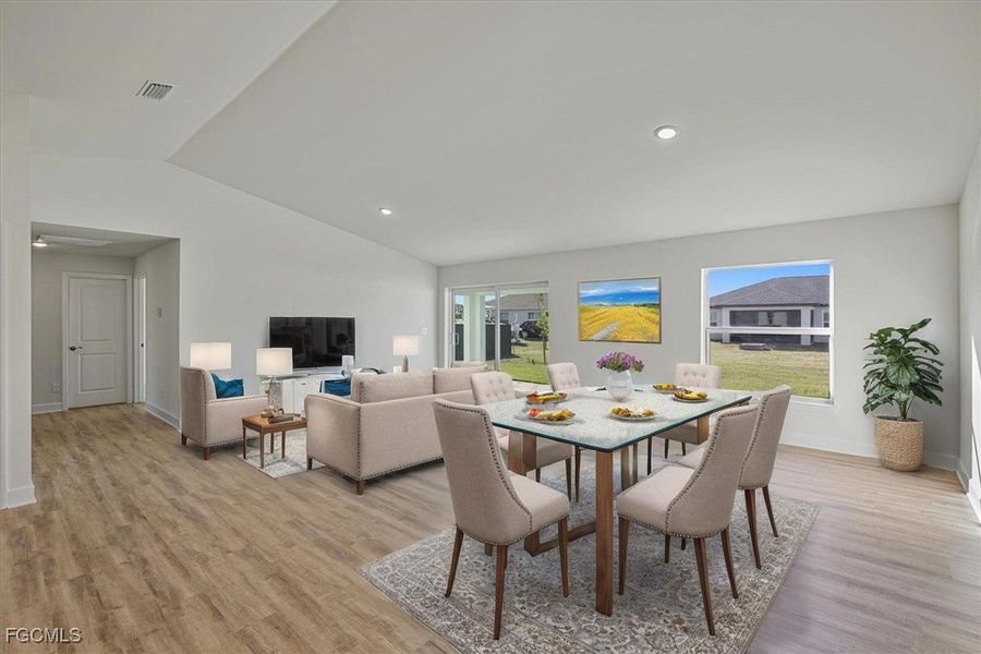 Dining room featuring light wood-type flooring, lofted ceiling, and recessed lighting