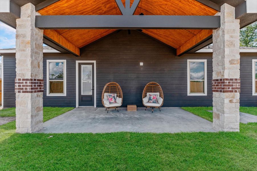 Expansive covered back porch with warm wood ceiling accents and recessed LED lighting—perfect for gatherings or quiet evenings. Expansive covered back porch with warm wood ceiling accents and recessed LED lighting—perfect for gatherings or quiet evenings.
