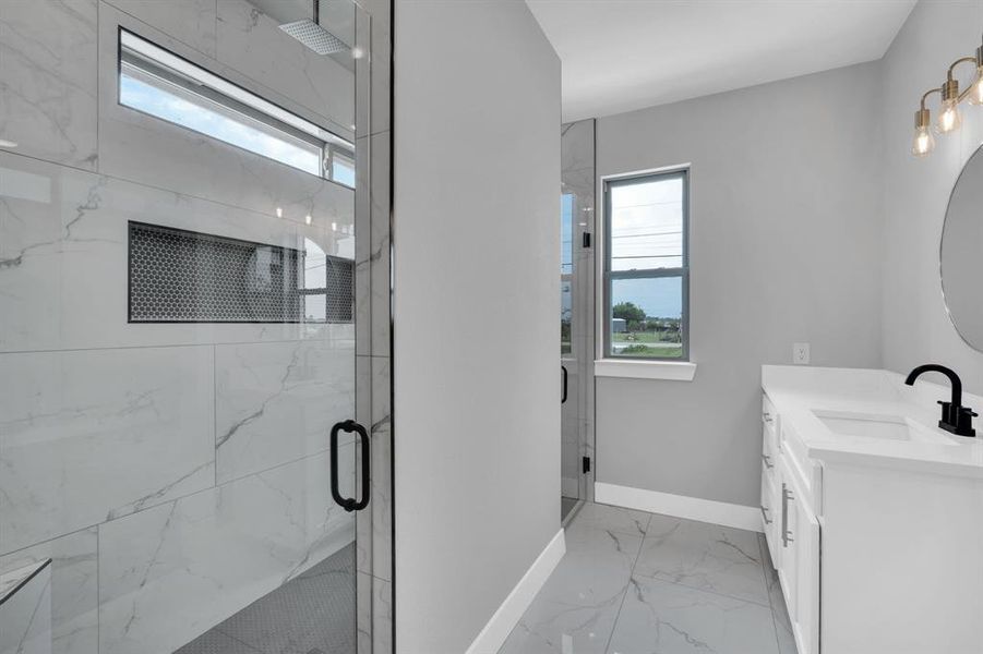 Bathroom with vanity, a shower with door, and tile patterned flooring