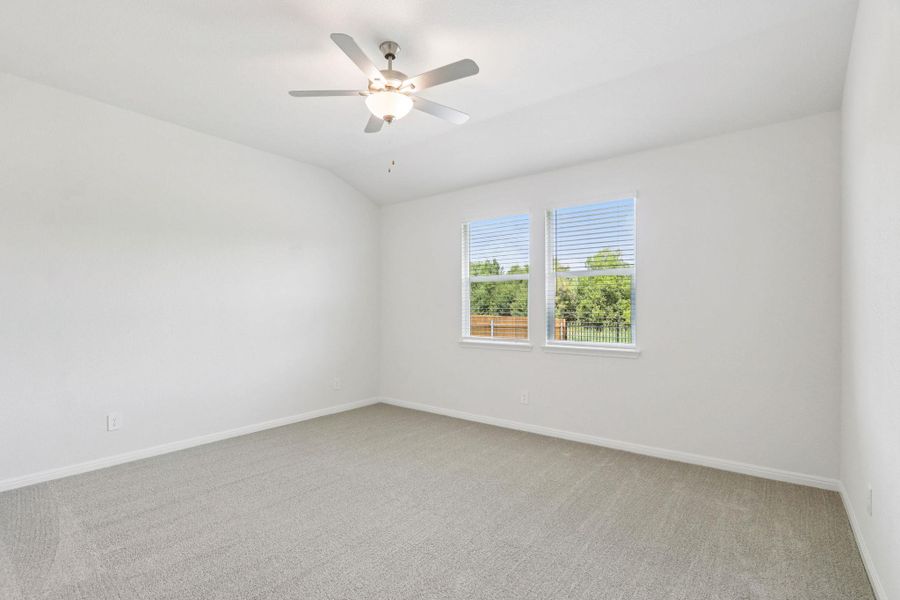 Spare room with light carpet, lofted ceiling, and a ceiling fan Spare room with light carpet, lofted ceiling, and a ceiling fan