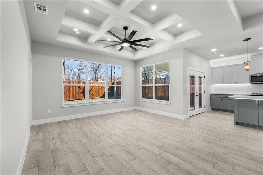 Kitchen featuring light wood-style floors, gray cabinets, stainless steel microwave, and baseboards