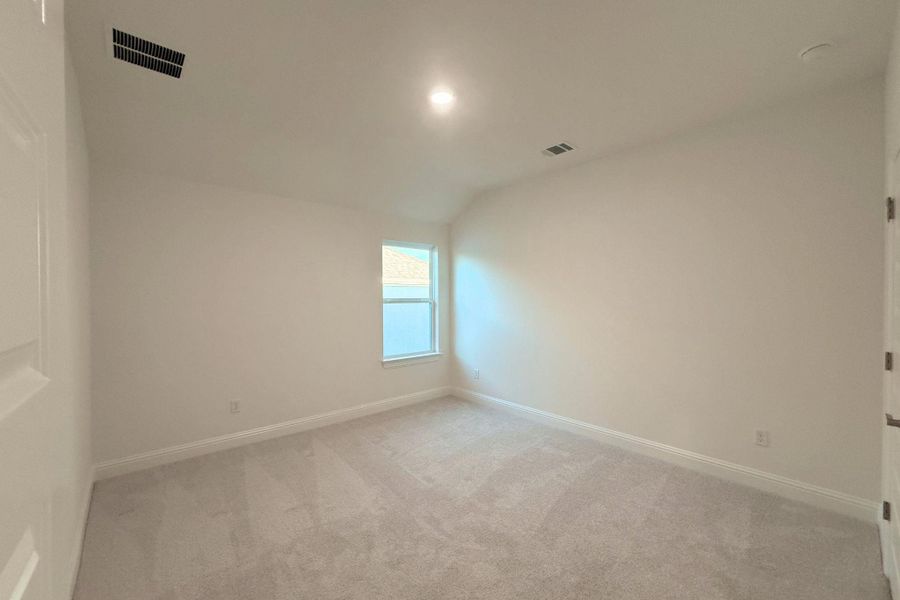 Empty room featuring light carpet, vaulted ceiling, and recessed lighting