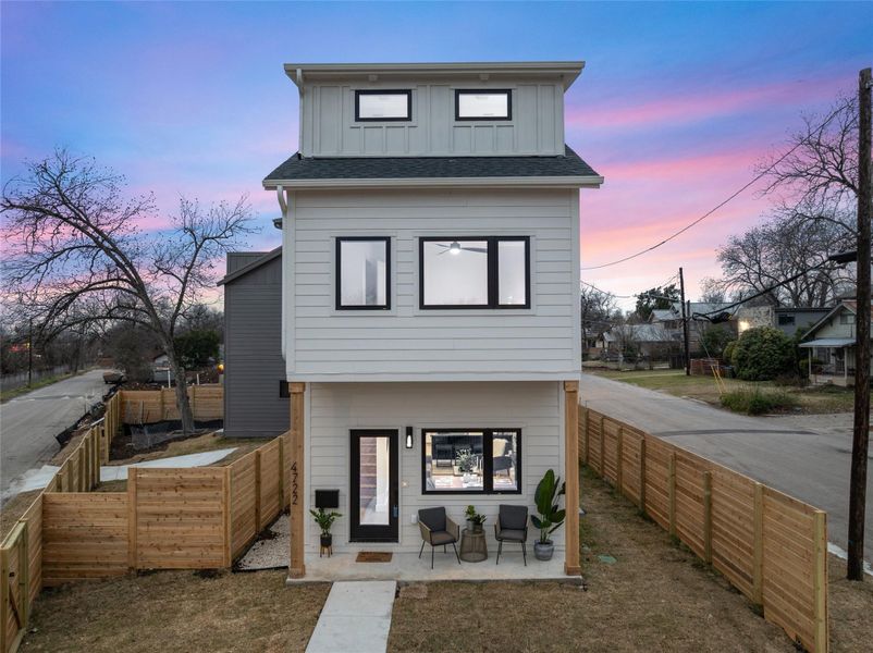 Rear view of property with board and batten siding and fence private yard