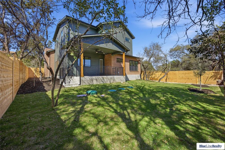 Rear view of property with a ceiling fan, a fenced backyard, and a patio area