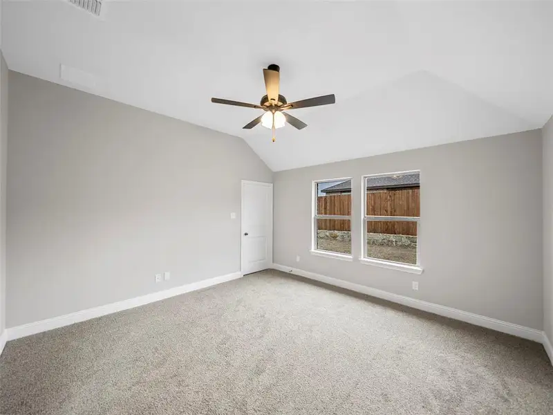 Carpeted spare room with visible vents, baseboards, a ceiling fan, and lofted ceiling Carpeted spare room with visible vents, baseboards, a ceiling fan, and lofted ceiling