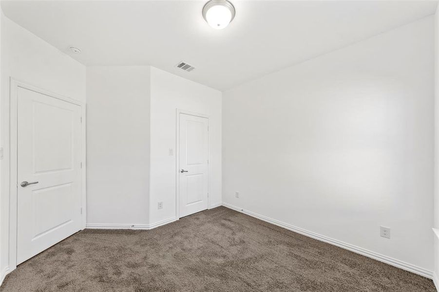 Empty room featuring dark carpet