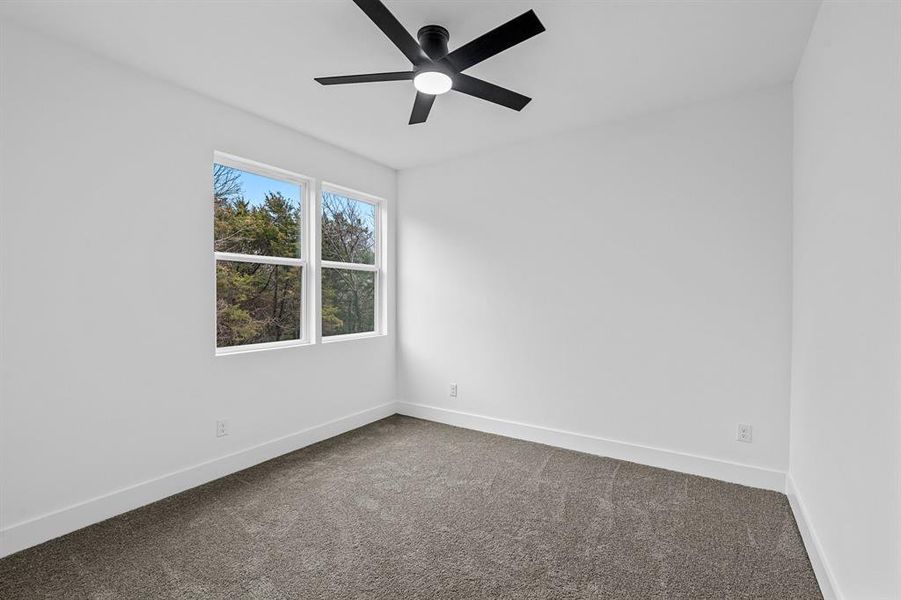 Carpeted spare room featuring ceiling fan