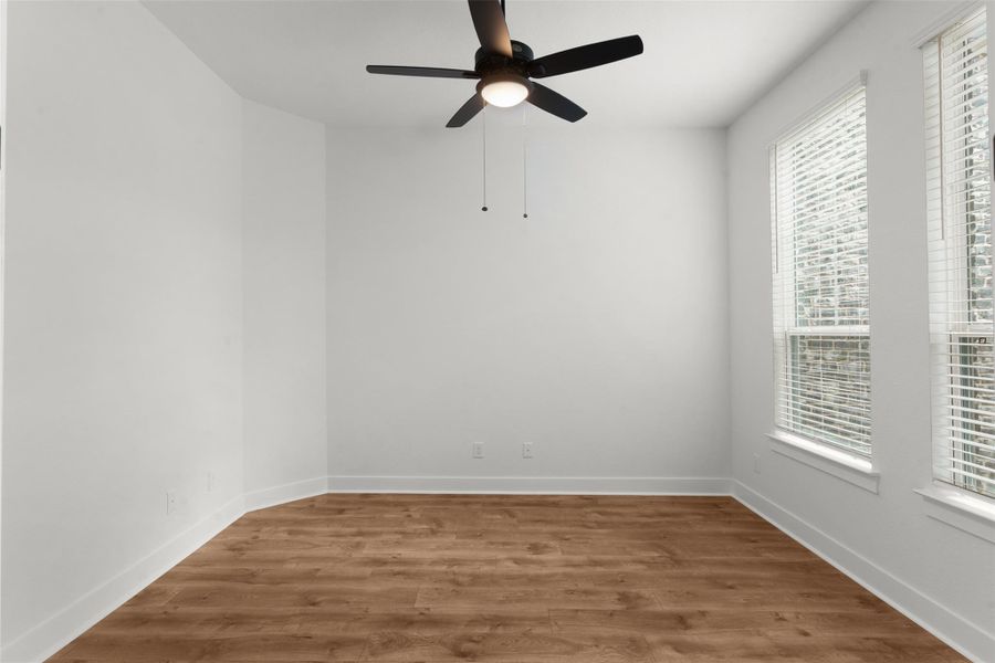 Empty room with wood finished floors and ceiling fan