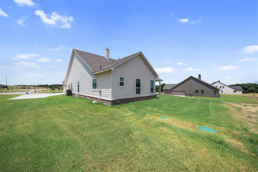 View of home's exterior with a chimney, a lawn, and a shingled roof View of home's exterior with a chimney, a lawn, and a shingled roof