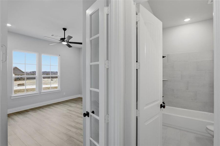 Full bath featuring recessed lighting, ceiling fan, washtub / shower combination, and light wood-type flooring