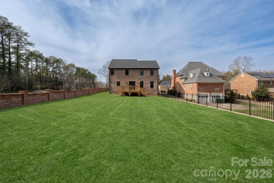 Backyard and rear view of the home. NOTE:The lawn has been recently seeded, and photography has been digitally enhanced to represent the yard at full, established growth.