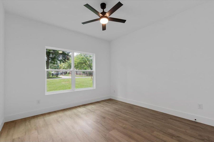 Unfurnished room featuring wood finished floors and a ceiling fan Unfurnished room featuring wood finished floors and a ceiling fan