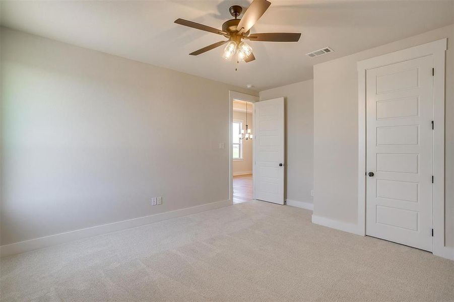 Unfurnished bedroom featuring light carpet, ceiling fan, baseboards, and visible vents Unfurnished bedroom featuring light carpet, ceiling fan, baseboards, and visible vents