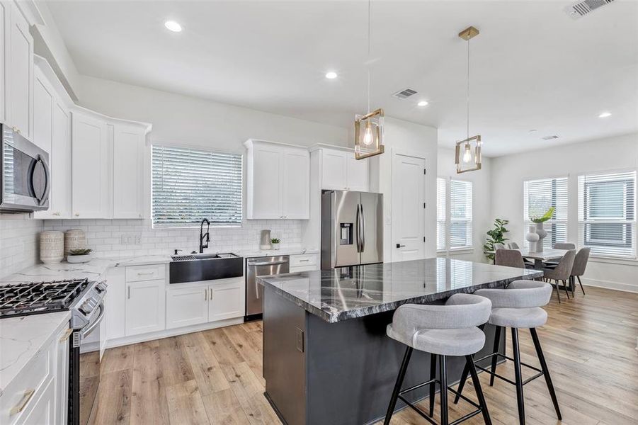 Kitchen island doubling as a stylish breakfast bar, illuminated by elegant drop lights overhead.