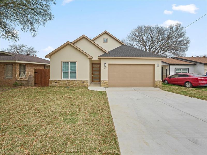 Single story home featuring stone siding, driveway, a garage, and stucco siding