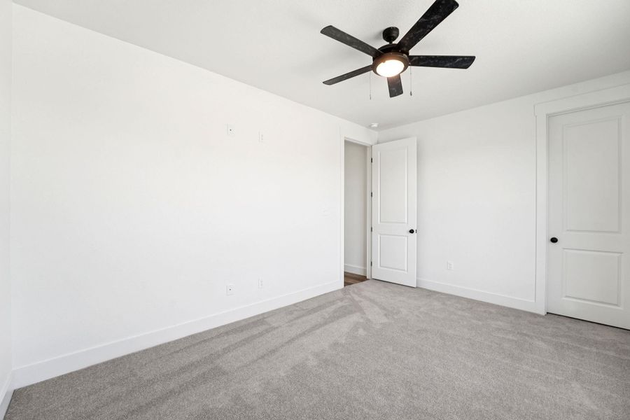 Unfurnished bedroom with carpet flooring and a ceiling fan