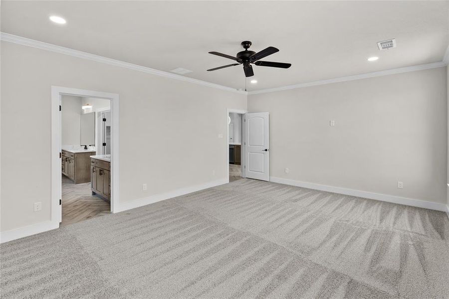 Spare room with light carpet, crown molding, and ceiling fan