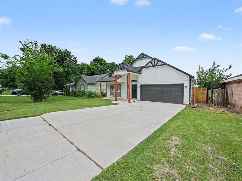 Modern farmhouse-style exterior with white board and batten siding, dark trim accents, and a dark garage door Modern farmhouse-style exterior with white board and batten siding, dark trim accents, and a dark garage door