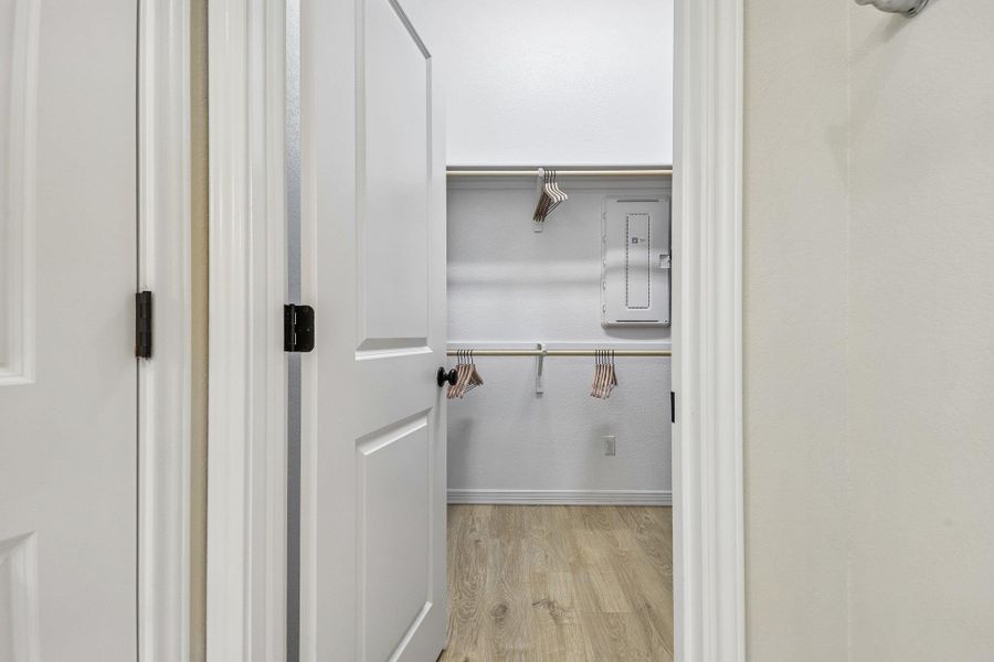 Step inside this well-organized closet featuring practical shelving and hanging rods.
