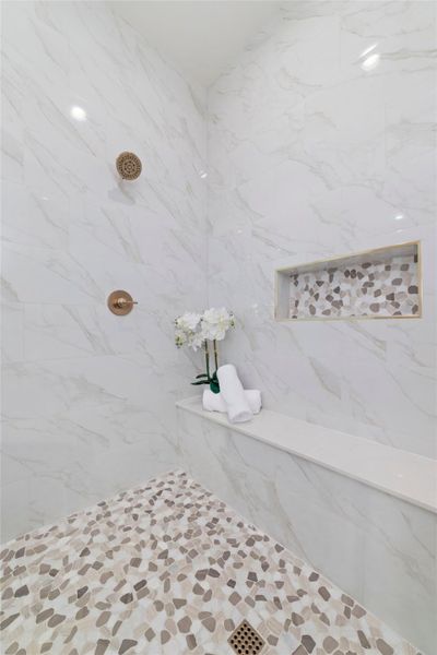 Oversized walk-in shower with designer tile and frameless glass.