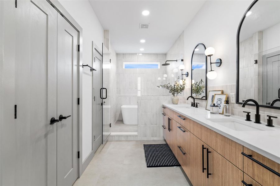 With a layout designed for ease and indulgence, this primary bathroom combines luxury and functionality—featuring a double vanity with quartz counters, matte black fixtures, and ample storage. A glass-enclosed shower and freestanding tub sit beneath a clerestory window, bathing the space in soft natural light for a spa-like experience every day. With a layout designed for ease and indulgence, this primary bathroom combines luxury and functionality—featuring a double vanity with quartz counters, matte black fixtures, and ample storage. A glass-enclosed shower and freestanding tub sit beneath a clerestory window, bathing the space in soft natural light for a spa-like experience every day.