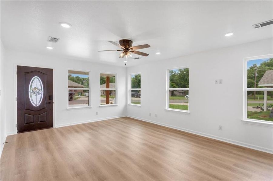 Front entry in living room featuring light wood flooring and ceiling fan