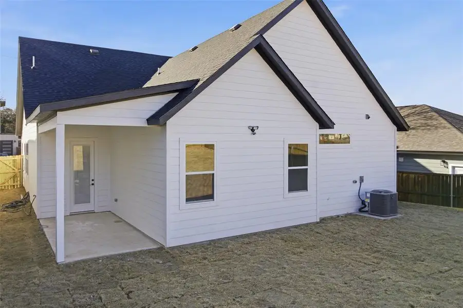 Back of property with a fenced backyard, a patio area, and a shingled roof