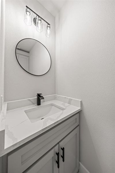 Bathroom featuring vanity and a textured wall