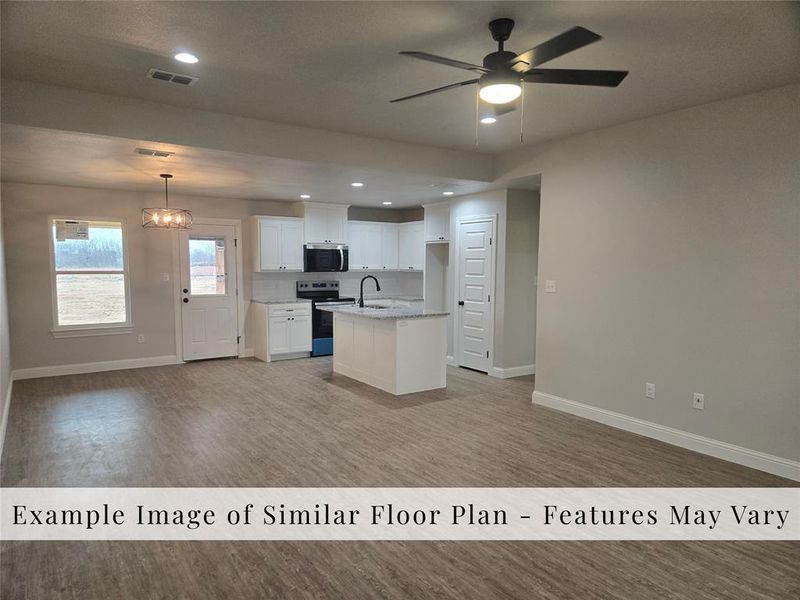 Kitchen with recessed lighting, open floor plan, white cabinets, and range with electric cooktop