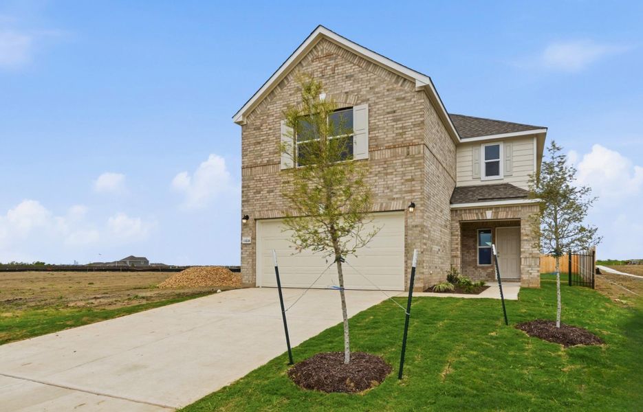 Front exterior of a new home in Stoney Chase, Del Valle, TX, highlighting curb appeal (Image 2). Front exterior of a new home in Stoney Chase, Del Valle, TX, highlighting curb appeal (Image 2).
