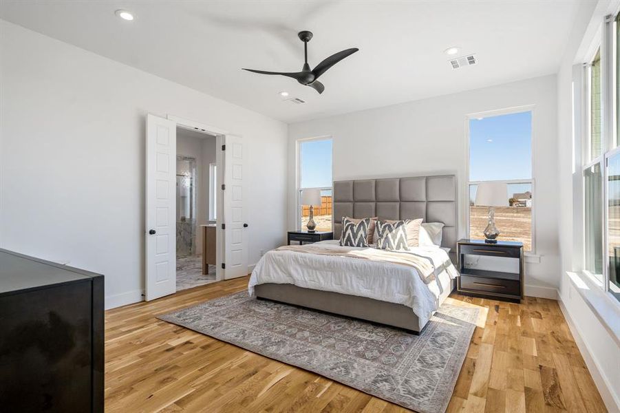 Bedroom featuring connected bathroom, ceiling fan, and light wood-type flooring