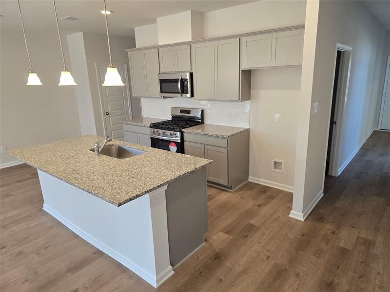 The Shetland III- Kitchen with center island. Home under construction. Sample floor plan photo used for illustrative purposes only. Upgrades, selections options, windows and colors may vary. The Shetland III- Kitchen with center island. Home under construction. Sample floor plan photo used for illustrative purposes only. Upgrades, selections options, windows and colors may vary.