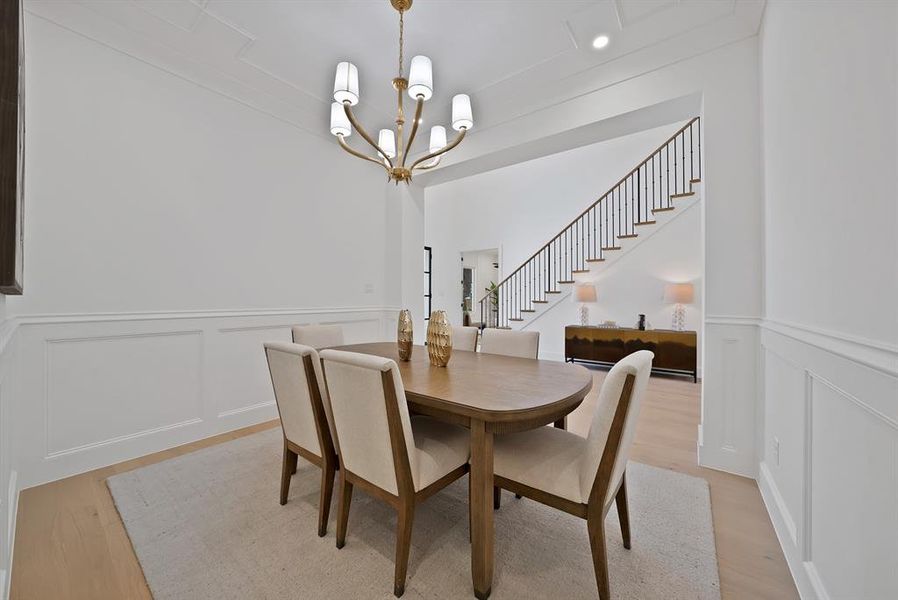 Dining area featuring wainscoting, wood-finish flooring, and a decorative chandelier