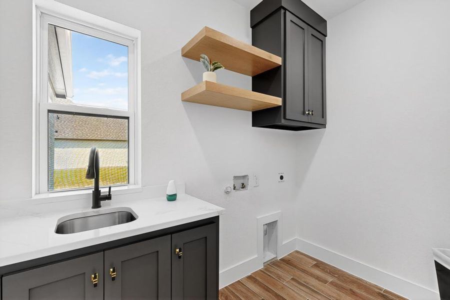 Washroom featuring cabinet space, washer hookup, electric dryer hookup, light wood-type flooring, and hookup for a gas dryer